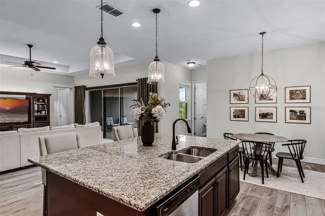 a kitchen with stainless steel appliances granite countertop a stove a kitchen island a dining table and chairs