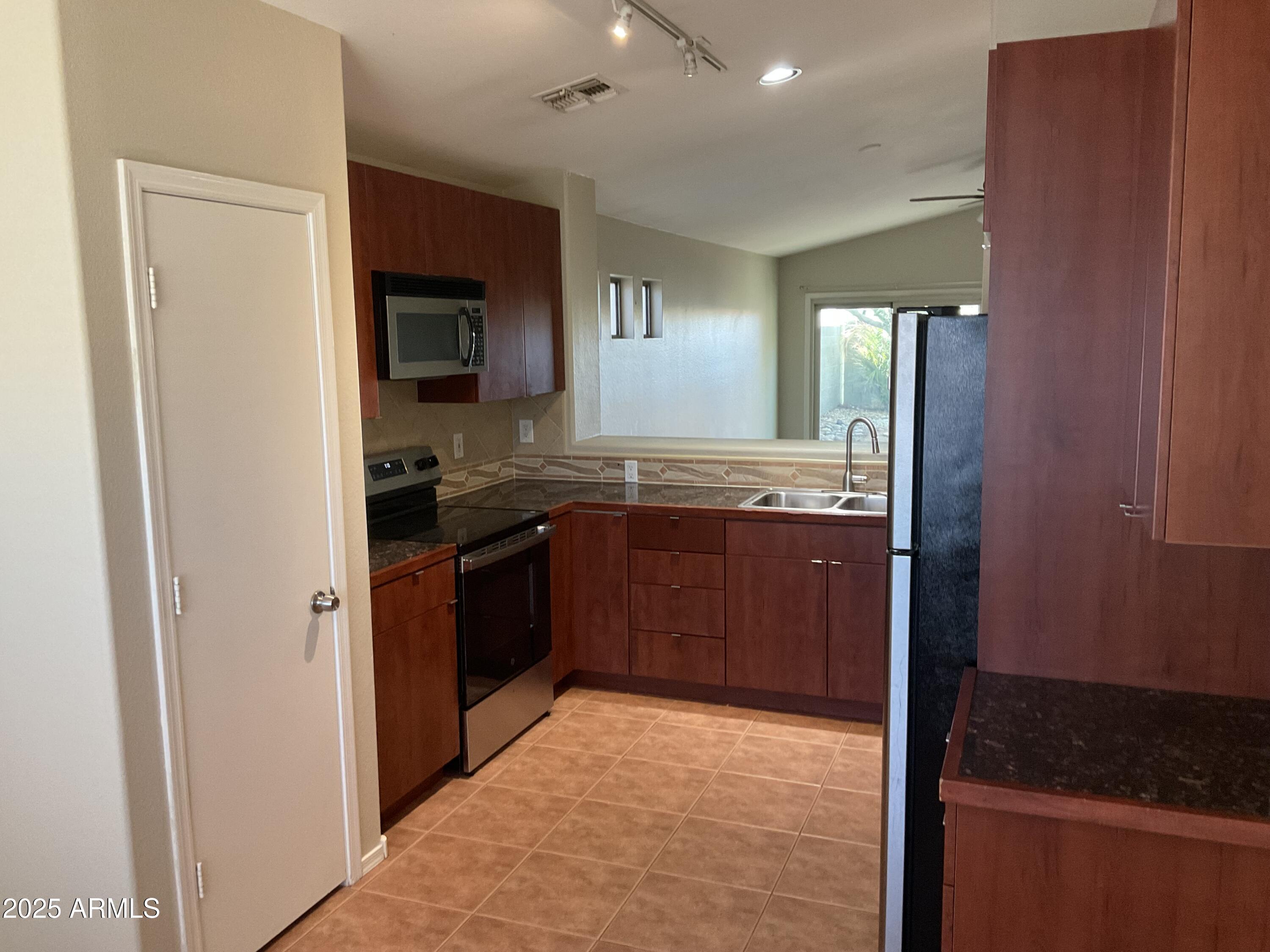 1896 South Pinto Drive Apache Junction, AZ 85120 - Photo 2 of 13 a kitchen with stainless steel appliances granite countertop a refrigerator and a sink