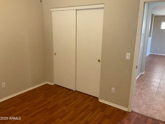 an empty room with wooden floor and closet