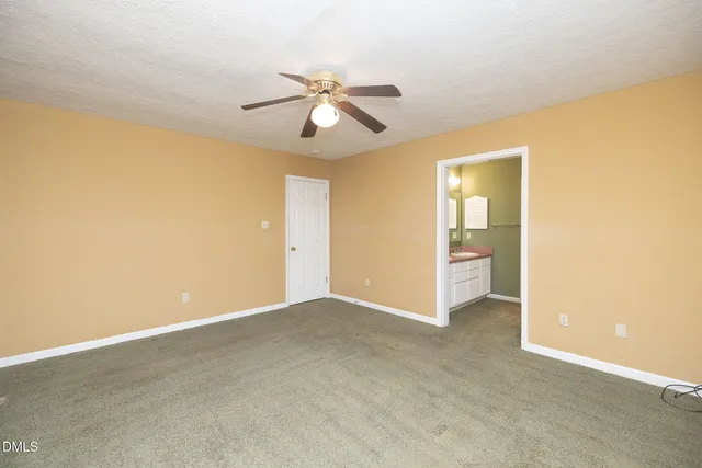 an empty room with closet and a chandelier fan