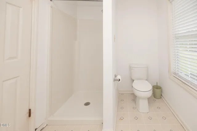 a bathroom with a toilet and a shower