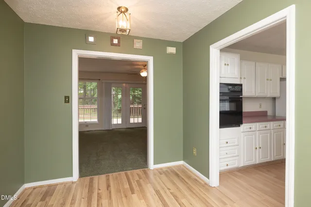 a view of a hallway with wooden floor and cabinet