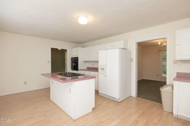 a view of kitchen with refrigerator stove and wooden floor