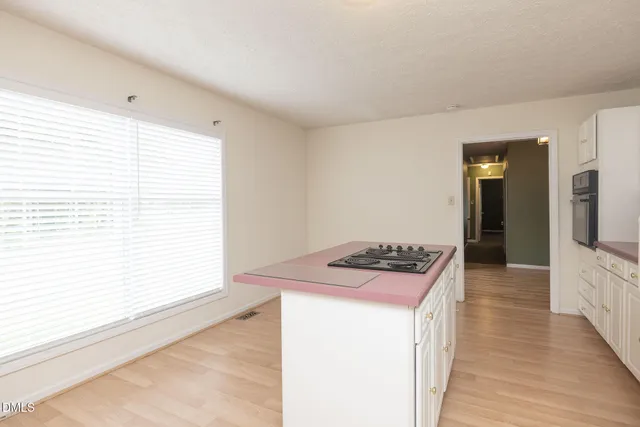 a kitchen with a stove and wooden floor