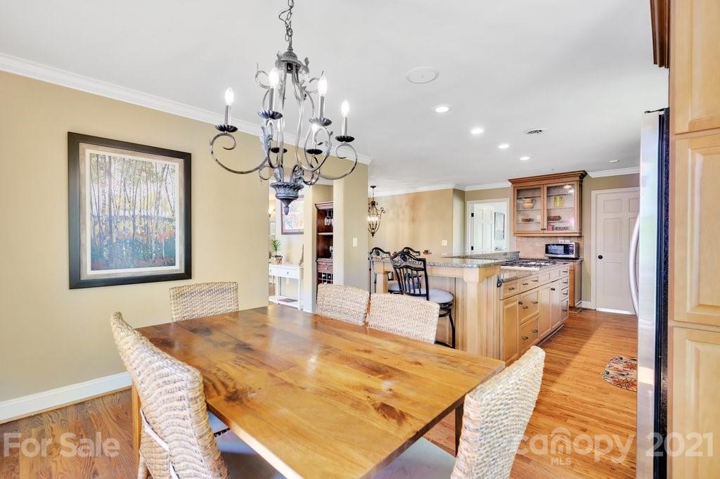 16123 Tana Tea Circle Tega Cay, SC 29708 - Photo 22 of 42 a view of a dining room and livingroom with furniture wooden floor a chandelier
