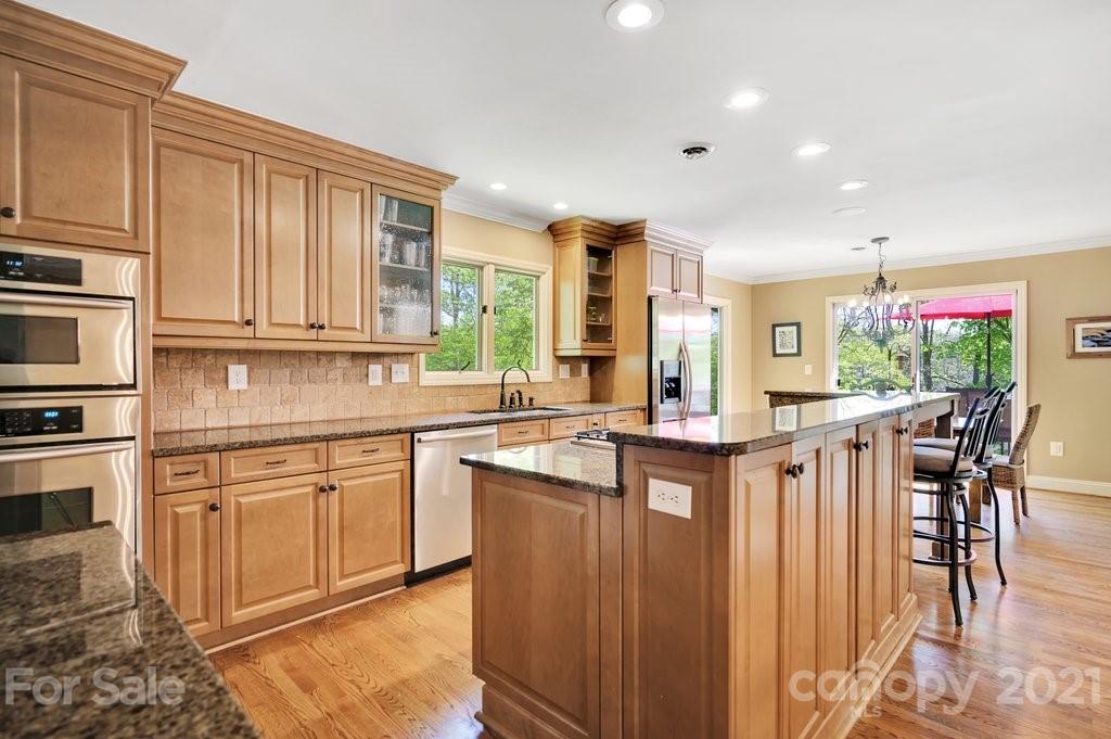 16123 Tana Tea Circle Tega Cay, SC 29708 - Photo 25 of 42 a kitchen with stainless steel appliances granite countertop a stove top oven a sink dishwasher and cabinets with wooden floor