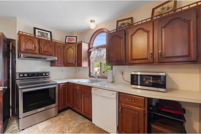 a kitchen with stainless steel appliances granite countertop a sink a stove a microwave and cabinets
