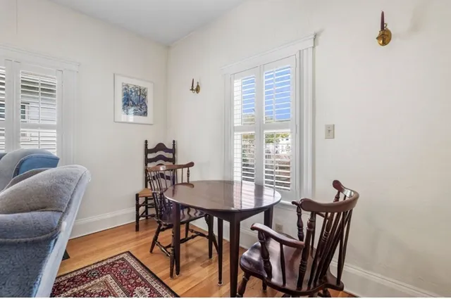 a view of a livingroom and dining room with furniture wooden floor and a window