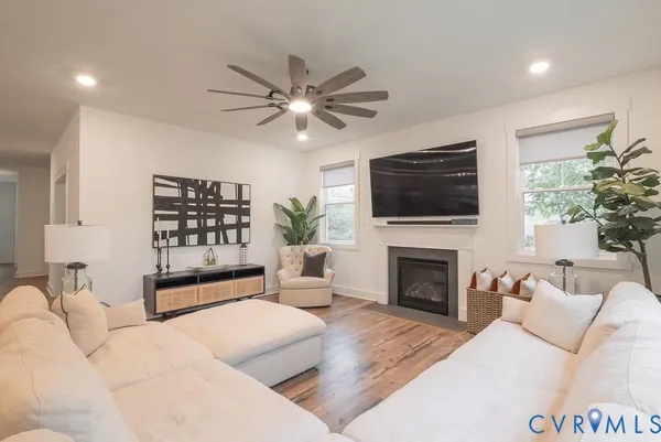 a living room with furniture a fireplace and a flat screen tv