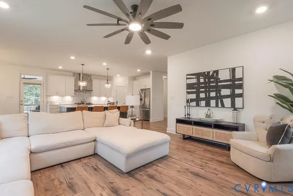a living room with furniture and a large window with kitchen view