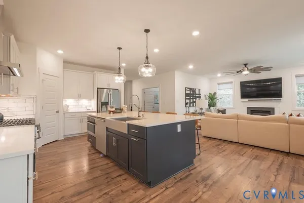 a large kitchen with stainless steel appliances kitchen island a large counter top and a wooden floors