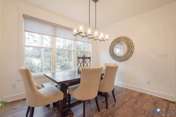 a dining room with furniture a chandelier and wooden floor