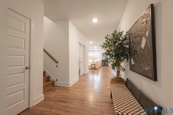 a view of a hallway with wooden floor and staircase