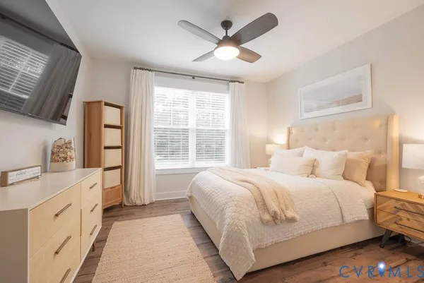 a bedroom with a large bed and a flat tv screen on dresser