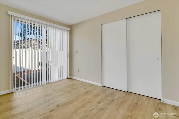 a view of a room with wooden floor and a window
