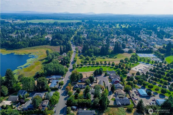 an aerial view of residential houses with outdoor space and trees