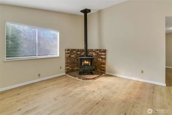 an empty room with wooden floor and a fireplace
