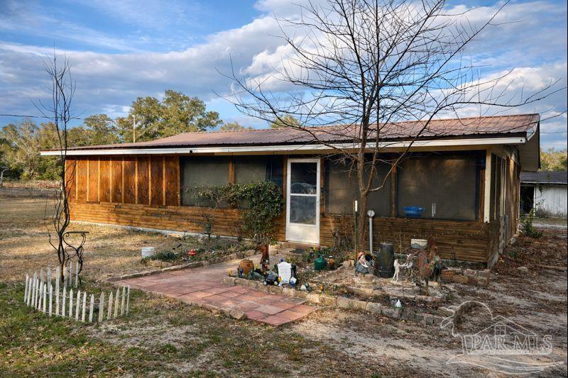 10246 Nichols Lake Road Milton, FL 32583 - Photo 18 of 43 a front view of a house with garden