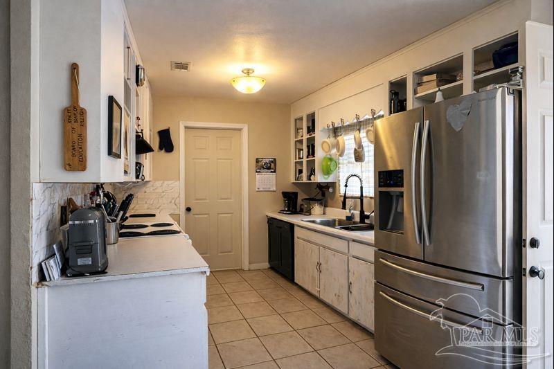 10246 Nichols Lake Road Milton, FL 32583 - Photo 19 of 43 a kitchen with a refrigerator and a sink