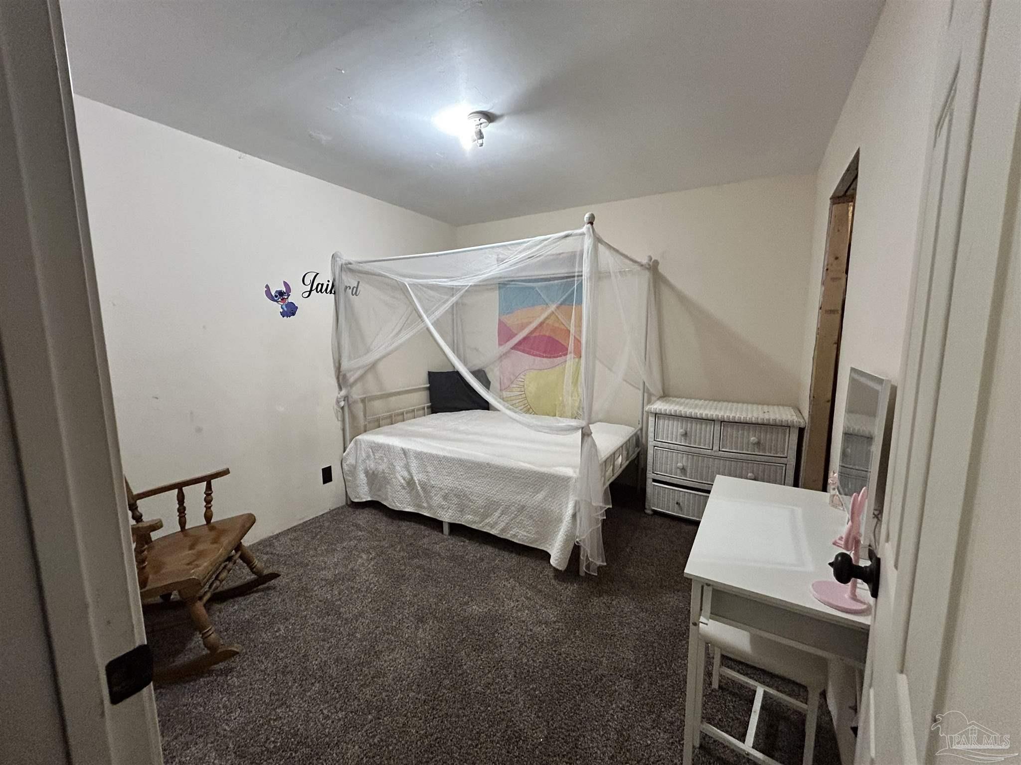 10246 Nichols Lake Road Milton, FL 32583 - Photo 25 of 43 a bedroom with a bed and wooden floor