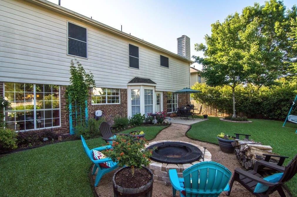 7517 Point Reyes Drive Fort Worth, TX 76137 - Photo 27 of 30 Expansive backyard featuring a stone-clad fire pit, meandering gravel pathways, and a mature shade tree