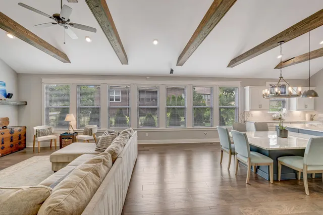 a living room with furniture a flat screen tv and a floor to ceiling window