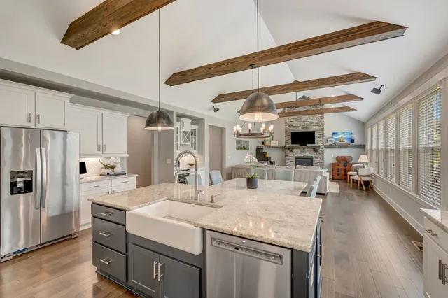 a dining room with stainless steel appliances kitchen island granite countertop a table chairs and a refrigerator