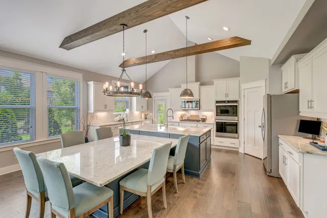 a kitchen with white cabinets and wooden floor