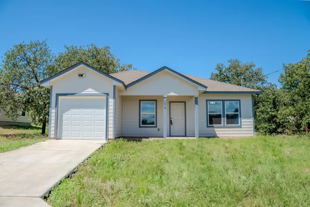 a front view of a house with a garden and yard