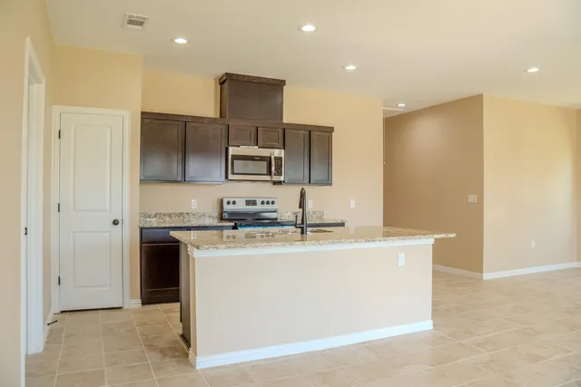 a kitchen with stainless steel appliances granite countertop a sink and a refrigerator