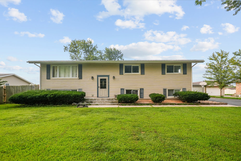 a front view of house with yard and green space
