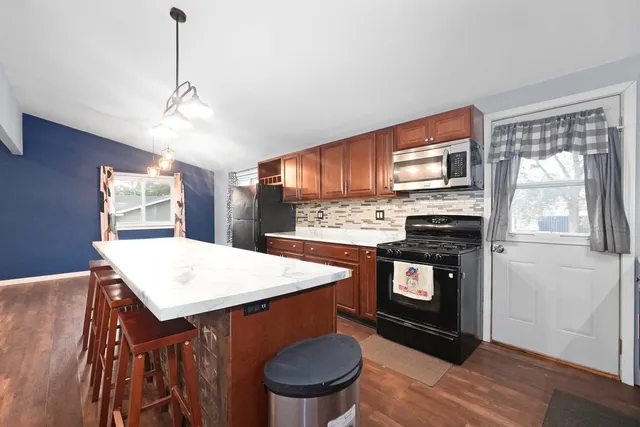 a kitchen with stainless steel appliances granite countertop a stove a sink and a refrigerator