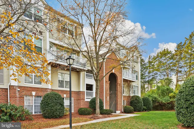 front view of a brick house with a yard