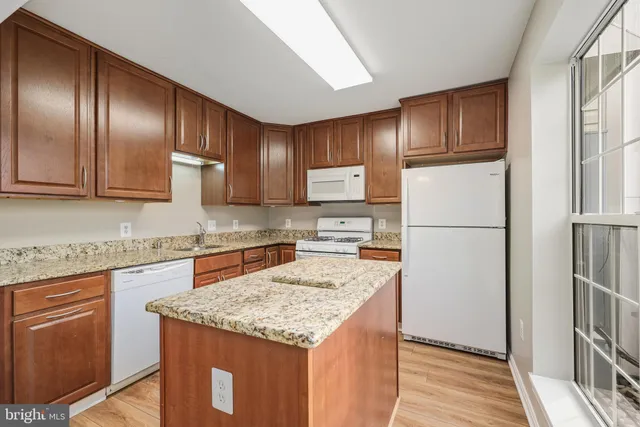 a kitchen with granite countertop stainless steel appliances and refrigerator