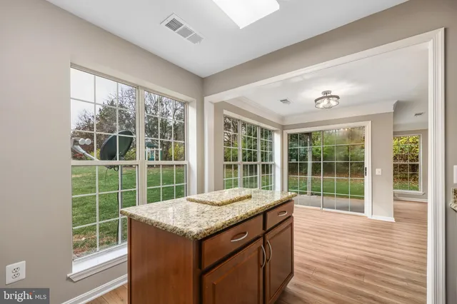 a kitchen with granite countertop a sink and a wooden floor