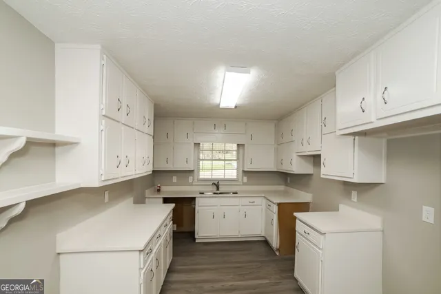 a kitchen with cabinets appliances a sink and a window