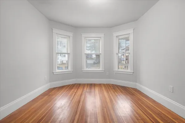 wooden floor in an empty room with a window
