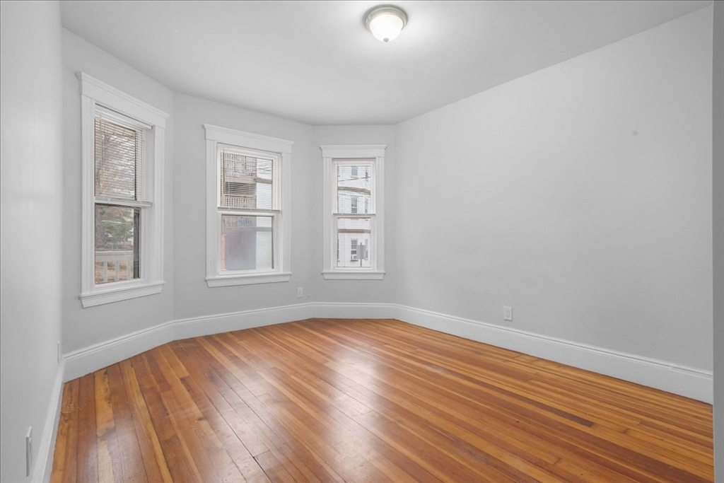 4 Bailey Street, Unit 1 Boston, MA 02124 - Photo 4 of 11 a view of an empty room with wooden floor and a window