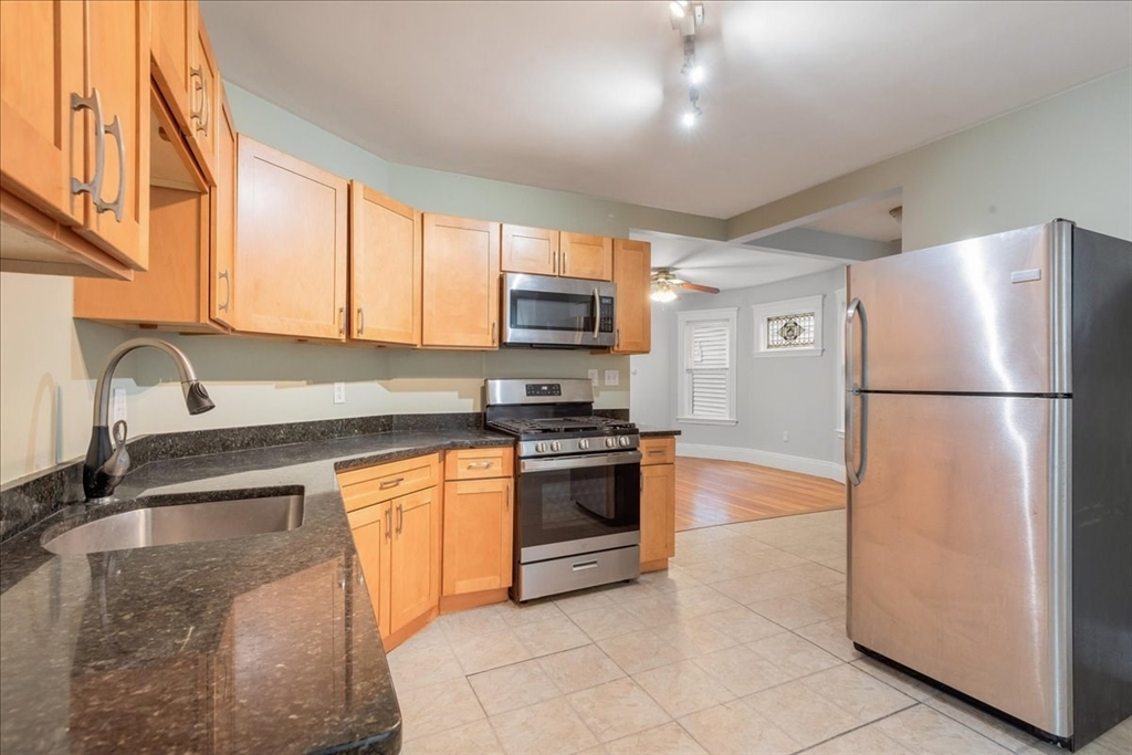 4 Bailey Street, Unit 1 Boston, MA 02124 - Photo 7 of 11 a kitchen with granite countertop a refrigerator and a sink