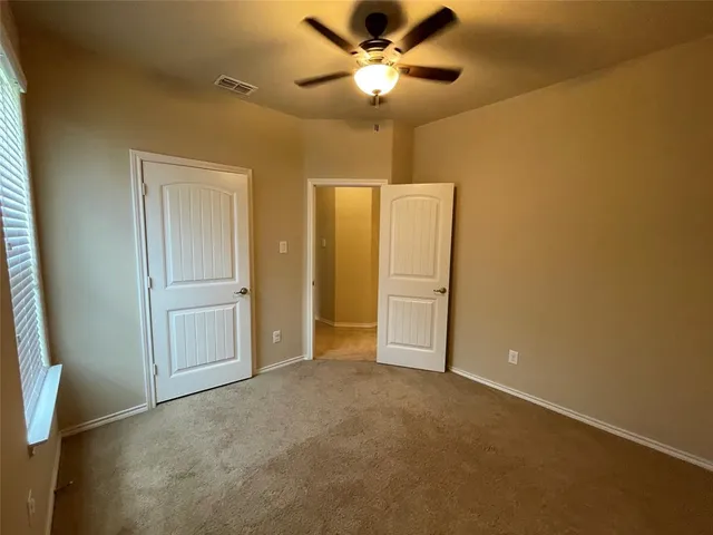 a view of empty room with ceiling fan