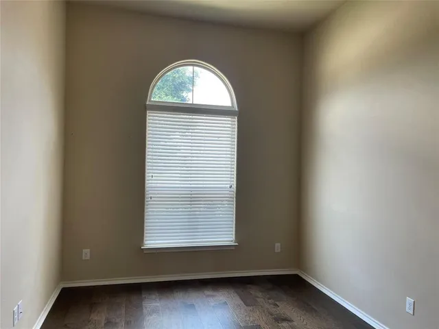 an empty room with wooden floor and a window