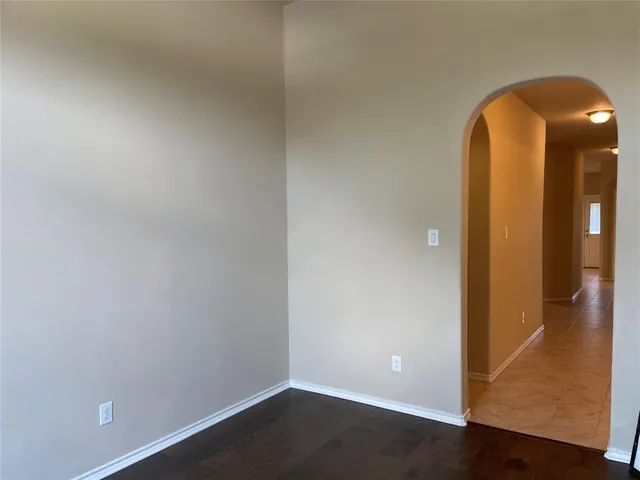 an empty room with wooden floor and a ceiling fan