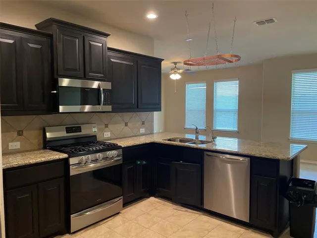 a kitchen with a sink and a stove top oven with wooden floor