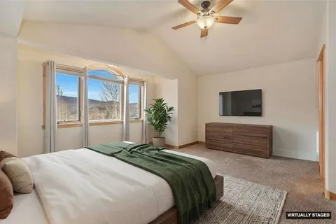 a bedroom with a bed and a large window