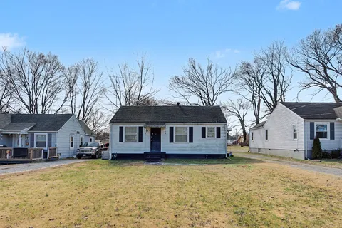a view of a house with a large tree and wooden fence