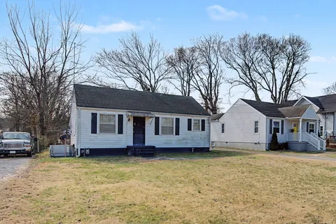 a view of a house with a large tree and a yard