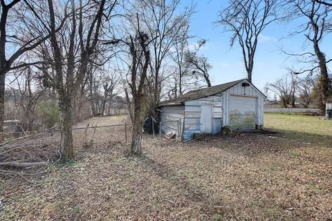 a view of a house with a yard and tree