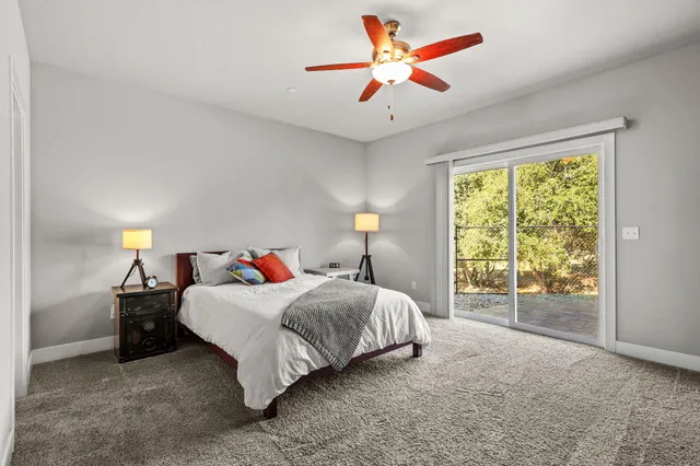 a spacious bedroom with a large bed chandelier and a dresser