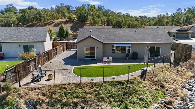 a view of a house with backyard sitting area and furniture