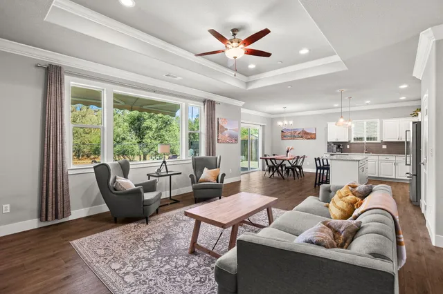 a kitchen with a dining table chairs wooden floor cabinets and stainless steel appliances